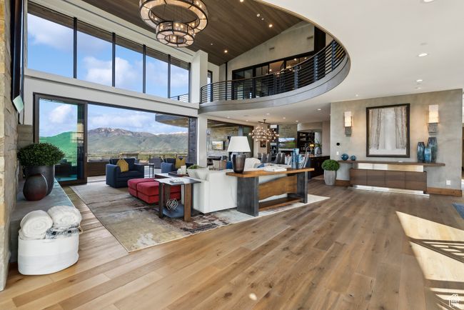 Living room with a chandelier, hardwood / wood-style floors, a mountain view, a high ceiling, and recessed lighting | Image 7