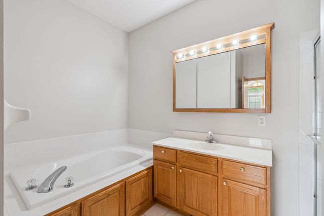 Owner private bath, separate soaking tub & shower, beautiful oak cabinetry. | Image 17