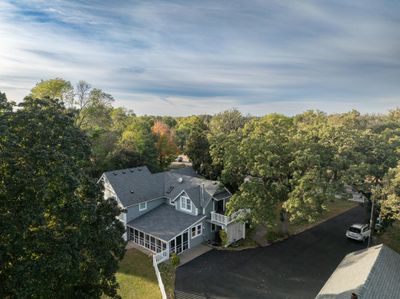 Beautiful aerial perspective of the house shows its location from over the barn; nestled on a 1 acre property adorned with majestic 100 year old oak trees and thriving mature maple trees | Image 2