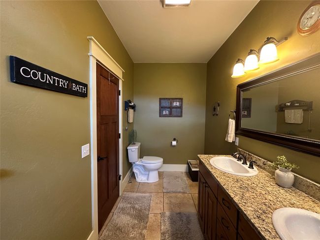 Bathroom with double vanity and stone tile floors | Image 13
