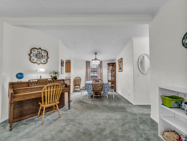 Carpeted dining room featuring ornamental molding, baseboards, and a desk | Image 17