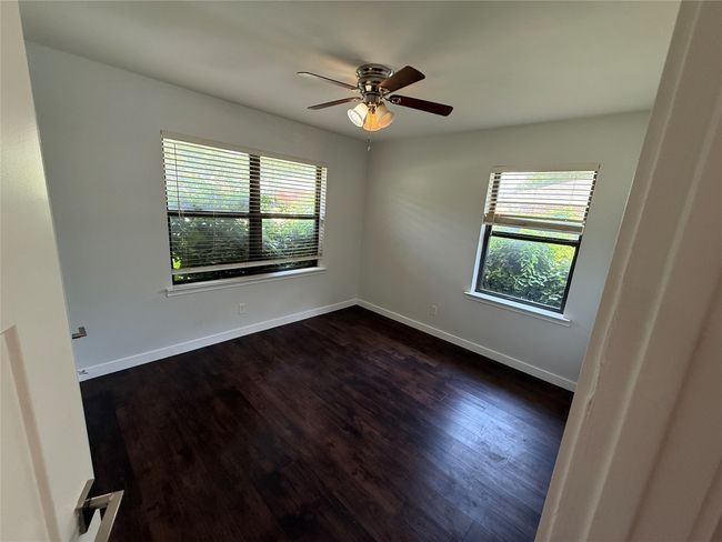 Spare room with plenty of natural light, dark wood finished floors, and a ceiling fan | Image 8