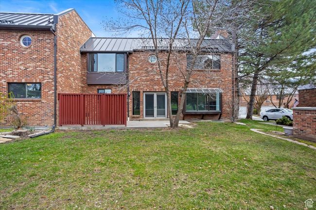 Back of property with a standing seam roof, a patio, metal roof, brick siding, and a yard | Image 44