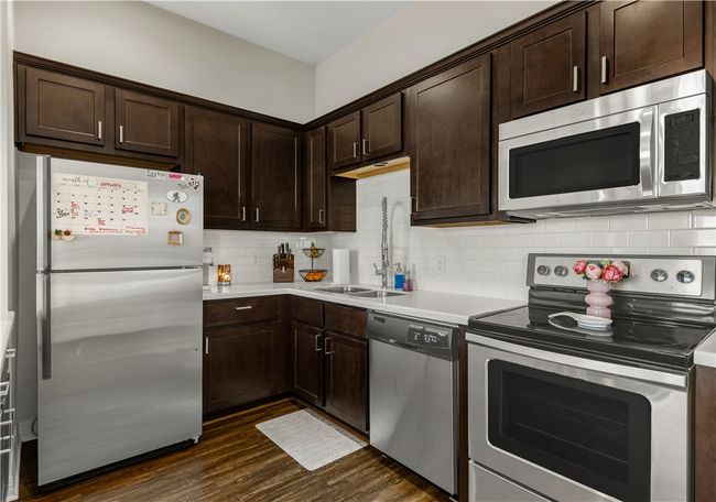 Kitchen with sink, tasteful backsplash, dark brown cabinets, dark hardwood / wood-style floors, and stainless steel appliances | Image 23