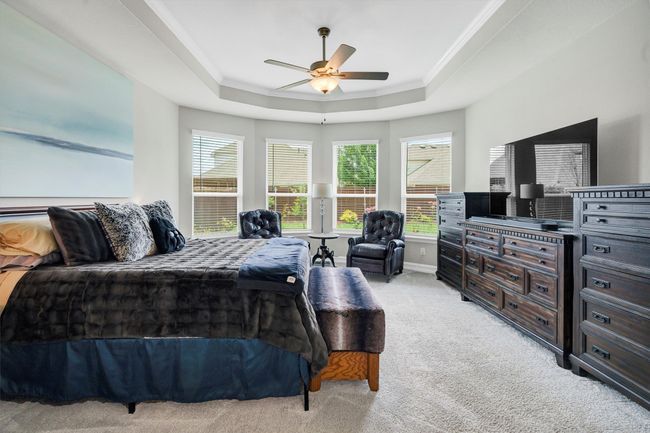 Primary bedroom features carpet, tray ceiling and ceiling fan for your added comfort. | Image 20