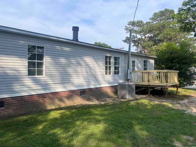 Rear view of property with a wooden deck, central air condition unit, crawl space, and a lawn | Image 25