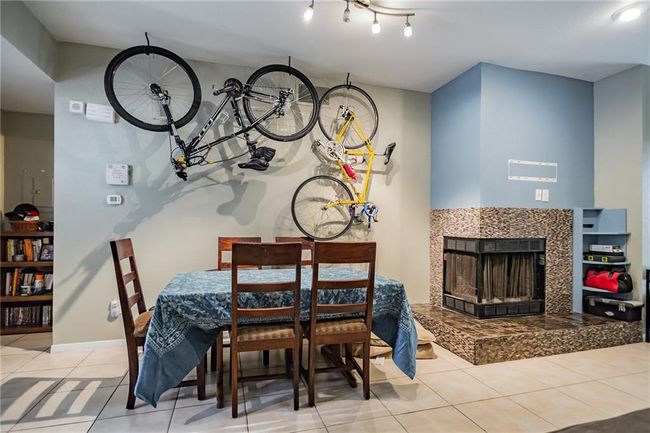 Dining space with tile patterned flooring, a tiled fireplace, and baseboards | Image 5