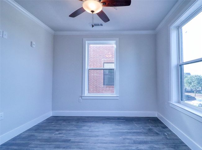 Spare room with dark wood-type flooring, ornamental molding, and plenty of natural light | Image 12
