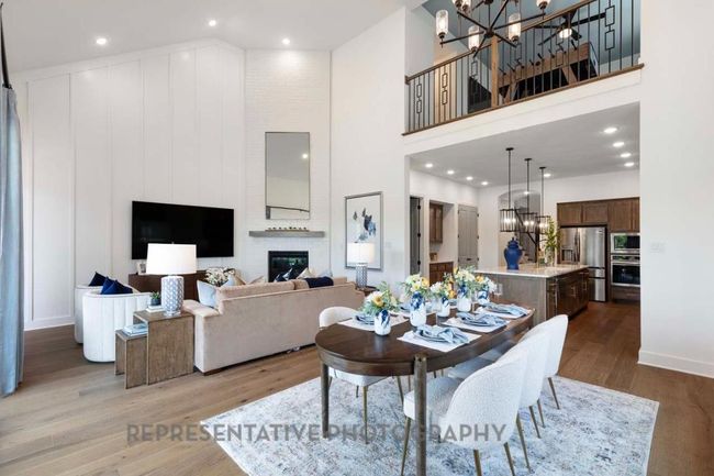 Dining room with a towering ceiling, a chandelier, wood finished floors, recessed lighting, and a fireplace | Image 23