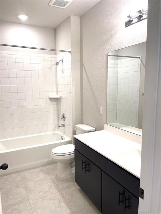Full bathroom with vanity, bathtub / shower combination, tile patterned flooring, a textured wall, and recessed lighting | Image 8