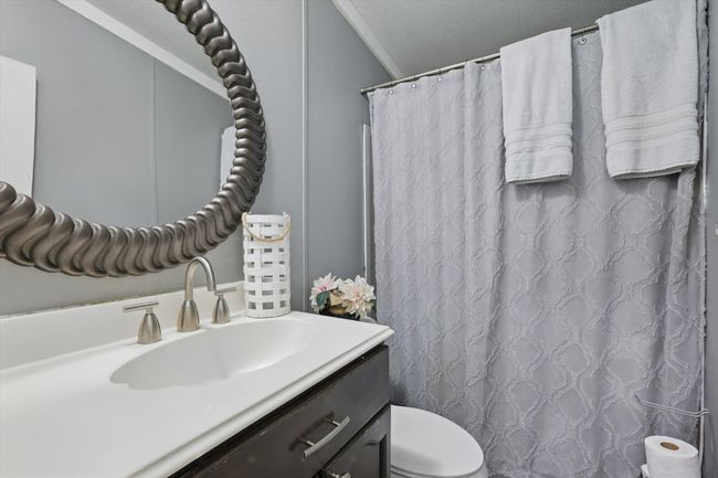 Full bathroom with vanity, a shower with shower curtain, and toilet | Image 19