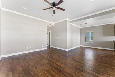 Spare room featuring dark hardwood / wood-style flooring, ceiling fan, and ornamental molding | Image 2