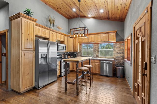 Kitchen featuring stainless steel appliances, tasteful backsplash, wood ceiling, and dark wood finished floors | Image 21