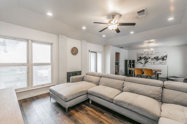 Unit 4900 Living room featuring dark wood-type flooring and ceiling fan with notable chandelier | Image 7