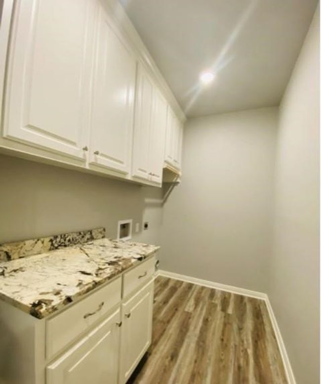 Laundry area with cabinet space, electric dryer hookup, baseboards, light wood-style flooring, and hookup for a washing machine | Image 10