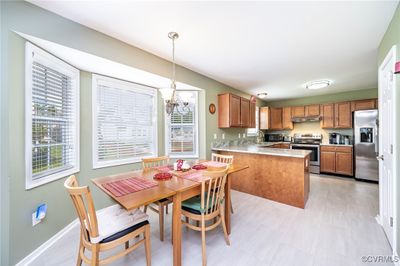 Kitchen featuring an inviting chandelier, plenty of natural light, kitchen peninsula, and stainless steel appliances | Image 2