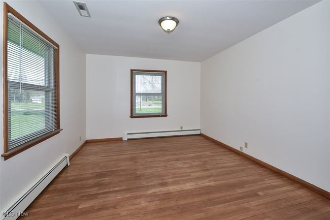 Empty room with baseboards, wood finished floors, and baseboard heating | Image 34