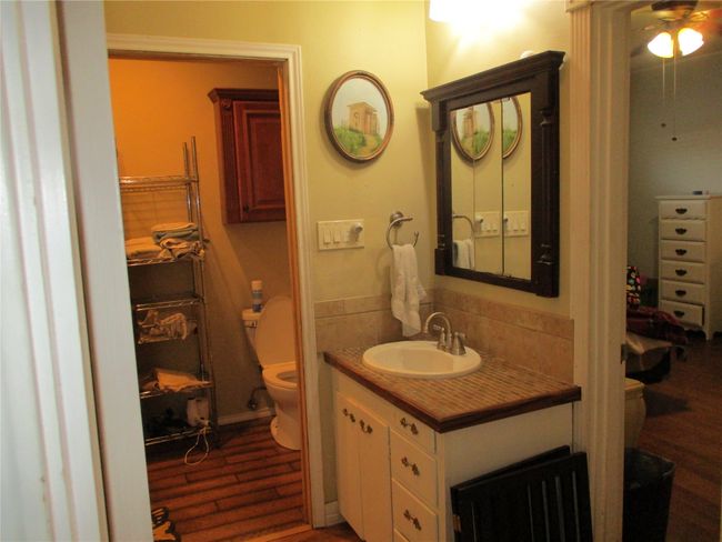 Bathroom with hardwood / wood-style floors, backsplash, toilet, vanity, and ceiling fan | Image 24
