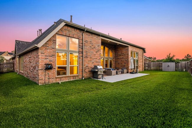 Enjoy your serene backyard at twilight hour under your covered patio with plenty of space for your kids and furry friends to run and play. | Image 34