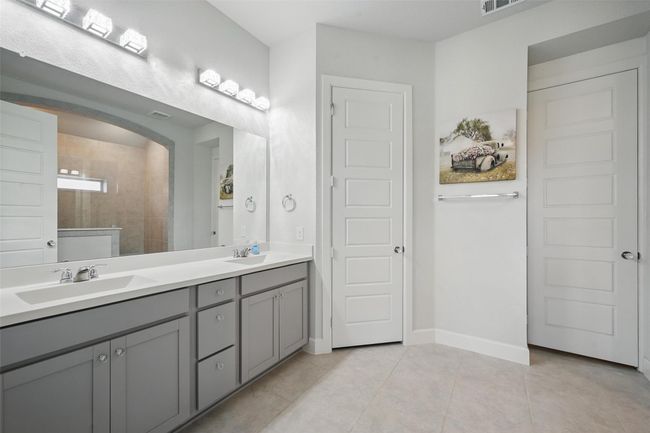 Bathroom with tile patterned flooring, double vanity, and baseboards | Image 15