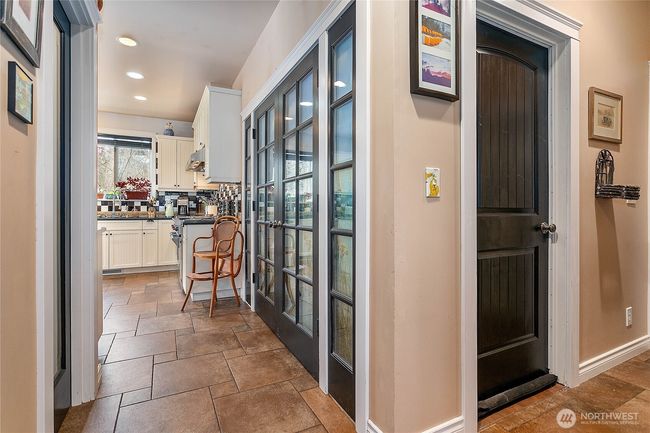 Back down on the main floor. Another entrance to the kitchen from the main entryway with walk-in pantry. The French doors/windows have been walled-off on the other side for a secondary living space. Can be accessed through the doorway in the hall. | Image 24