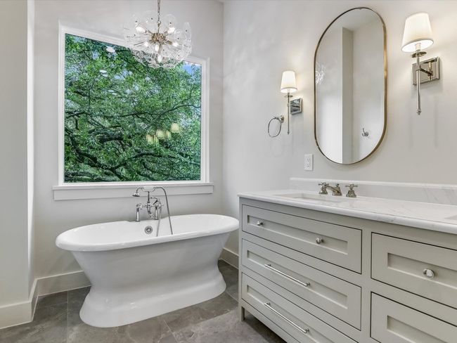 Bathroom featuring a freestanding bath, baseboards, vanity, and a healthy amount of sunlight | Image 13