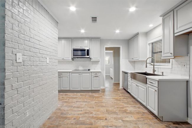 This beautifully appointed kitchen delivers on every detail, from upgraded lighting to stylish finishes that elevate the heart of the home. The effortless flow to the home's main areas make it easy to cook while entertaining. | Image 5