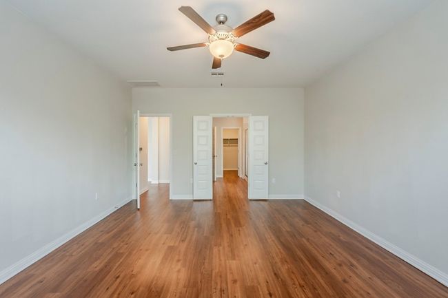 Unfurnished bedroom with visible vents, wood finished floors, baseboards, a closet, and a spacious closet | Image 13