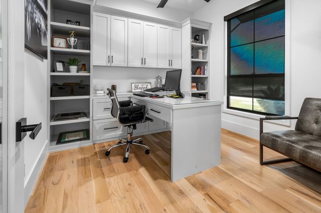 Home office with built in study area, light wood-style flooring, and baseboards | Image 25