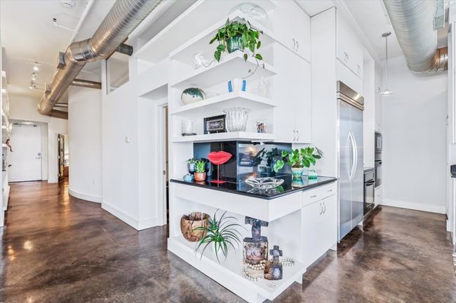 Hall featuring finished concrete flooring, open shelving and Ink granite counters. | Image 17