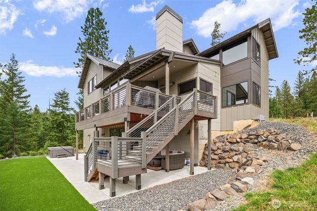 Great view of the main floor deck with stairs to the yard, patio on yard level, artificial turf for easy care and great place for yard sports and then the hot tub ready for a relaxing dip. | Image 23
