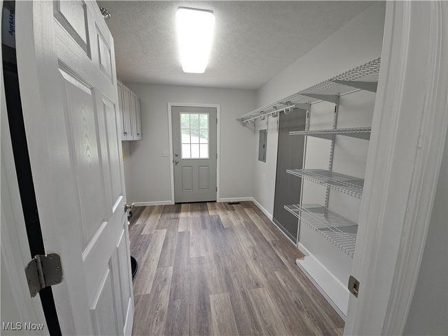 Large laundry and utility room with shelving for pantry storage and exterior door to sidewalk | Image 14