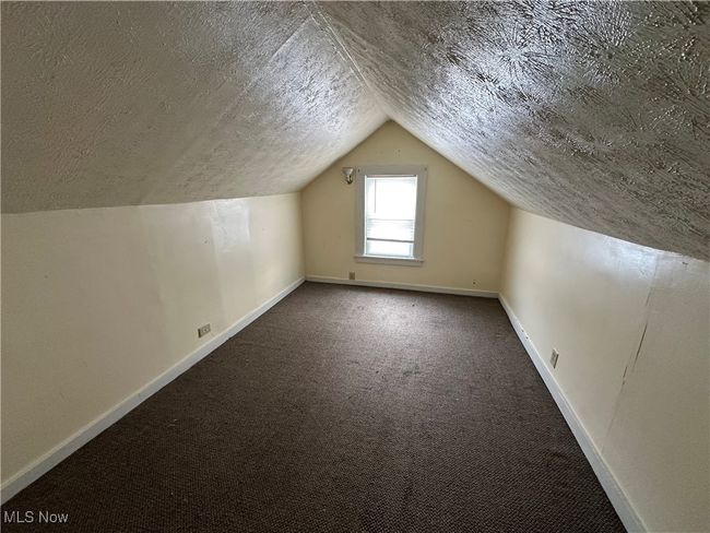 Bonus room featuring lofted ceiling, carpet flooring, and a textured ceiling | Image 6
