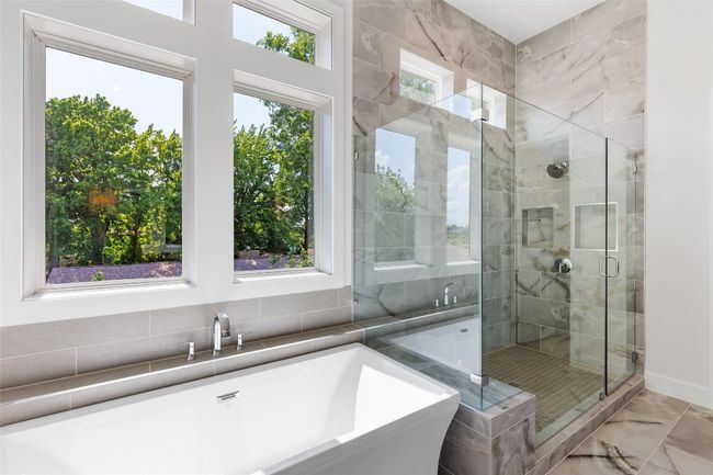 Freestanding bath, a shower stall, and marble finish flooring. | Image 25