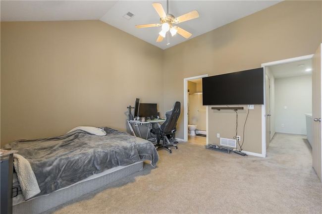 Bedroom with visible vents, light colored carpet, ensuite bathroom, and vaulted ceiling | Image 12
