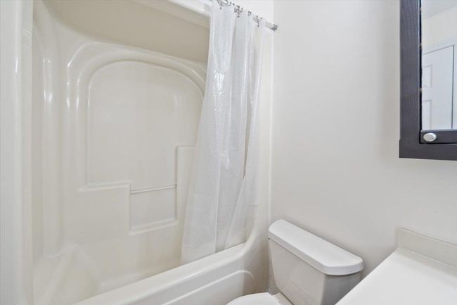 Full bathroom featuring toilet and shower / tub combo with curtain | Image 19