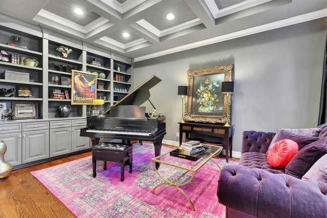 The formal living area, just beyond the foyer, is a showpiece of elegance and comfort. A wall of custom grey built-in cabinetry adds both function and sophistication, while the coffered ceiling with recessed lighting adds architectural depth and warmth, creating an ideal space for both quiet relaxation and refined entertaining. | Image 6