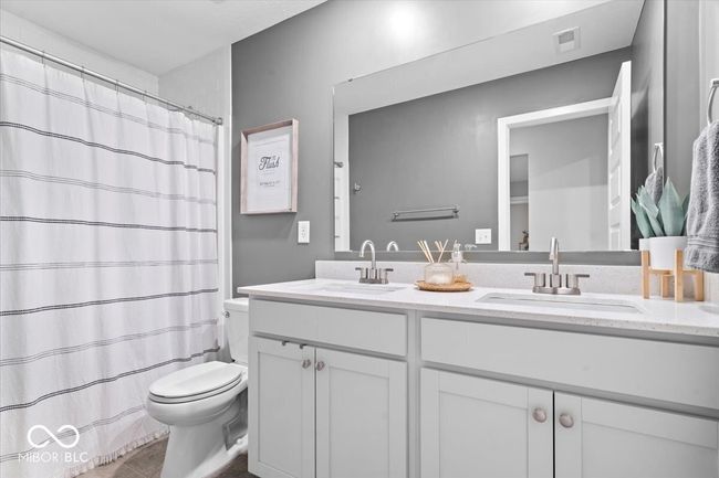 bathroom featuring double vanity, a shower with curtain, and tile patterned flooring | Image 32