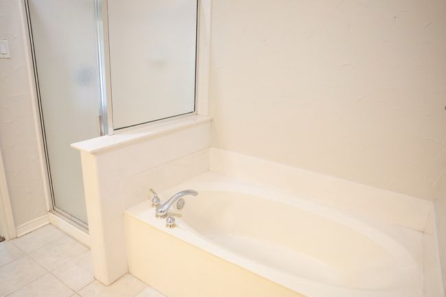 Bathroom with a garden tub, tile patterned flooring, and a stall shower | Image 36