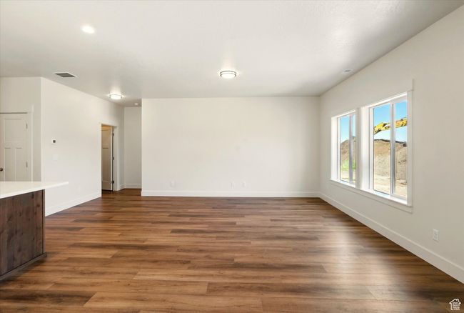 Unfurnished living room featuring dark wood-style flooring and baseboards | Image 11