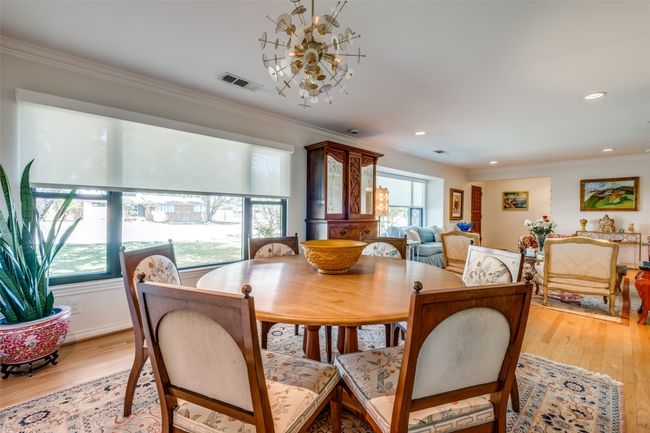 Dining space featuring ornamental molding, light hardwood / wood-style flooring, and a notable chandelier | Image 10