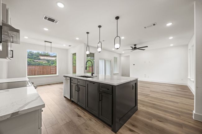 Kitchen featuring a sink, stainless steel dishwasher, light wood finished floors, ceiling fan, and recessed lighting | Image 12