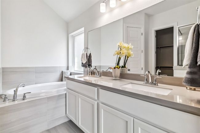 Bathroom featuring double vanity, lofted ceiling, and a garden tub | Image 32