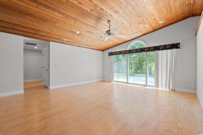 Spare room featuring lofted ceiling, wood ceiling, a ceiling fan, and light wood finished floors | Image 6