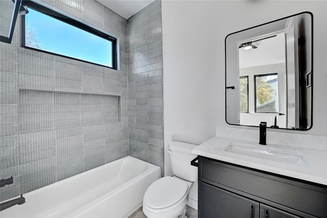 Full bathroom with a healthy amount of sunlight, toilet, shower / bathing tub combination, and vanity | Image 14