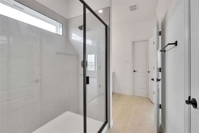 Bathroom with a shower stall and tile patterned floors | Image 7