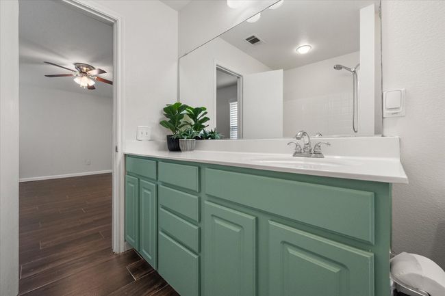 Full bathroom featuring wood finished floors, vanity, and a tub & shower combo | Image 15