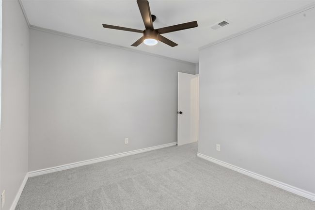 Empty room featuring ceiling fan, crown molding, and carpet | Image 16
