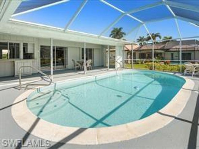 View of swimming pool featuring a patio area and glass enclosure | Image 23