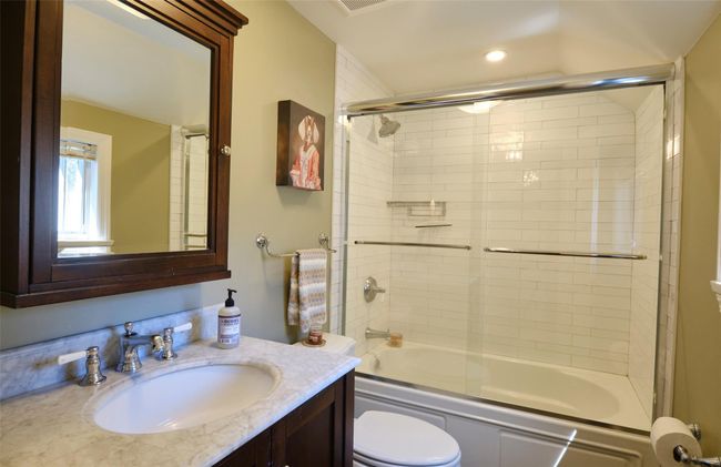 Full bathroom with combined bath / shower with glass door, toilet, and vanity | Image 20